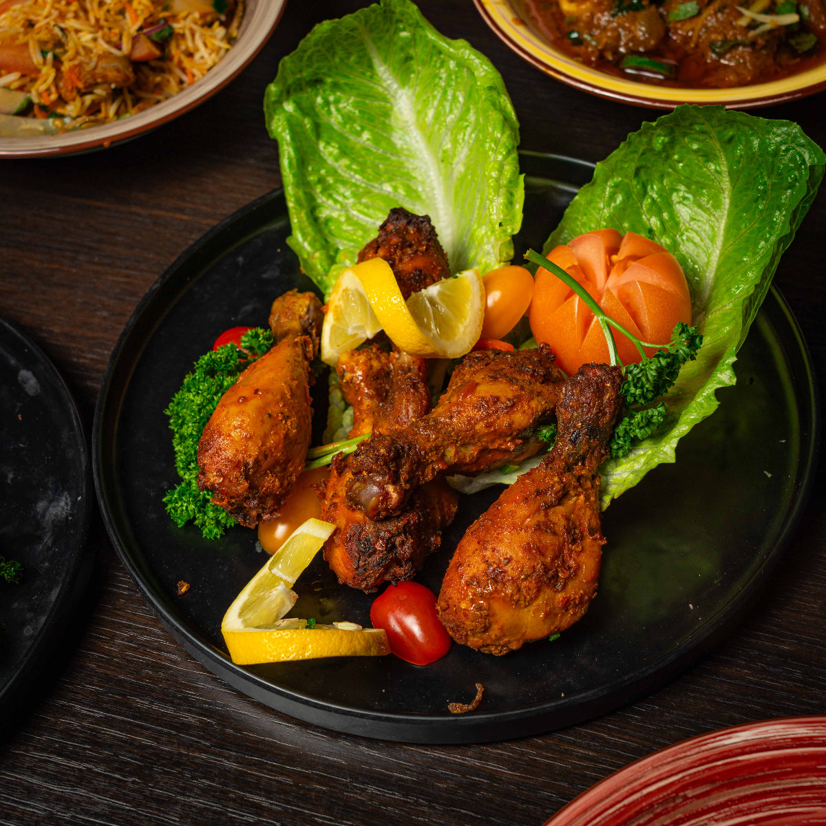 Plated fried chicken with vegetables on a dark surface